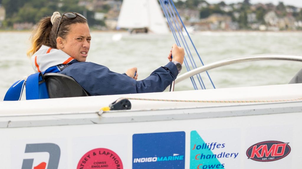A lady sailing from a seated position in a sonar keelboat