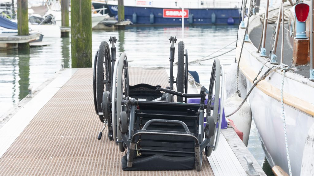 a pair of wheelchairs sit inverted on a pontoon